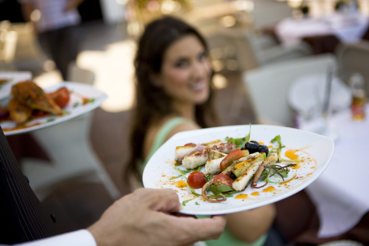 Waiter delivering a plate of food to customer