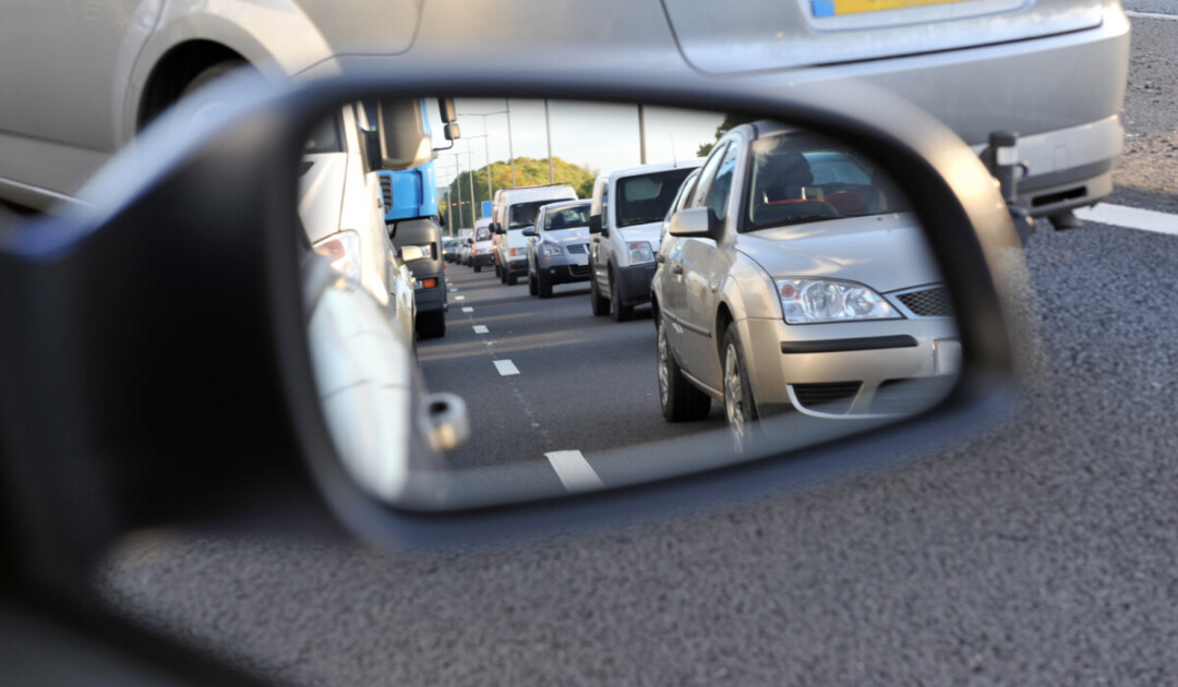 Highway traffic reflected in a vehicle mirror 