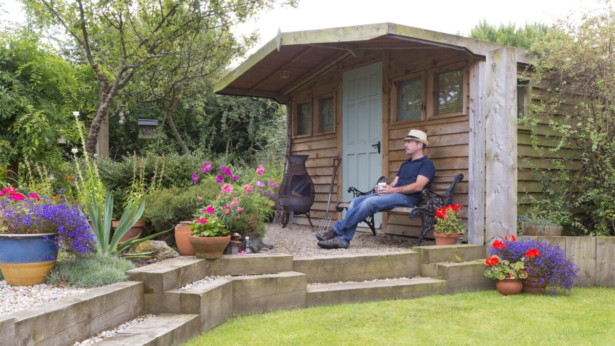 Worker relaxing by a she shed on a patio