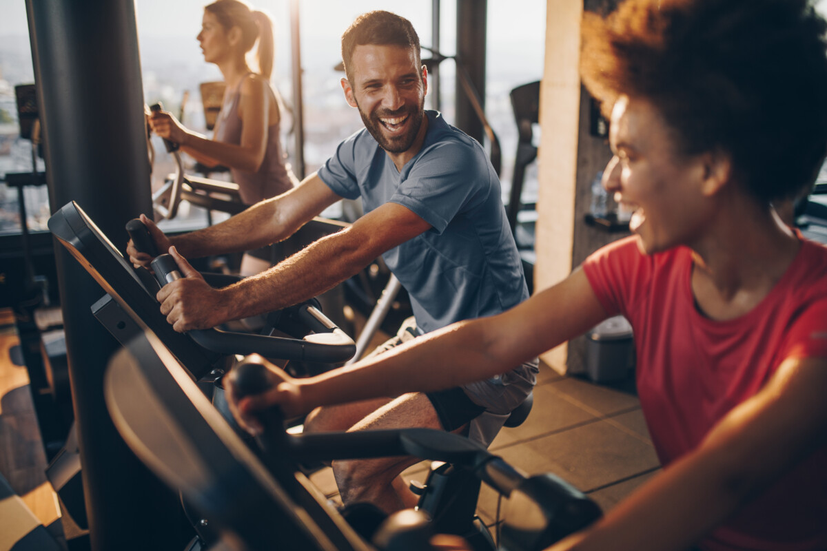 a man and a women cycling in a gym