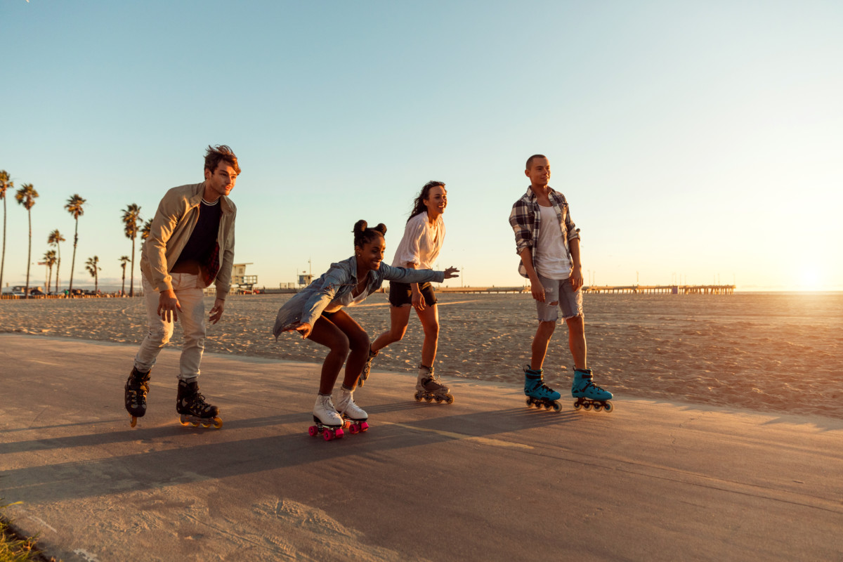 Friends roller skating on the boardwalk in Venice Beach - Santa Monica promenade _ getty