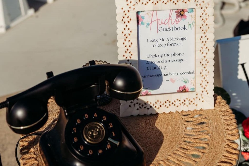 a rotary phone sits on a table with a sign about leaving a message in the audio guestbook--one idea in Redfin's graduation party ideas article