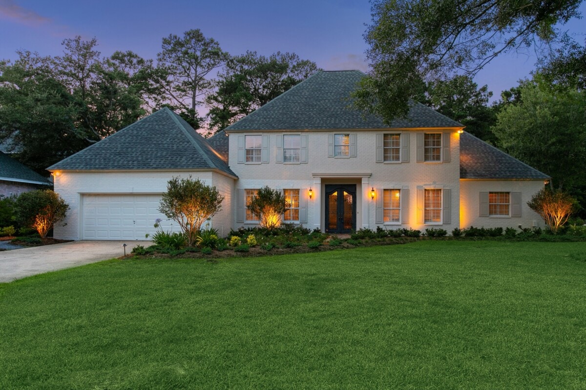 luxury white home with lush yard in lousiana