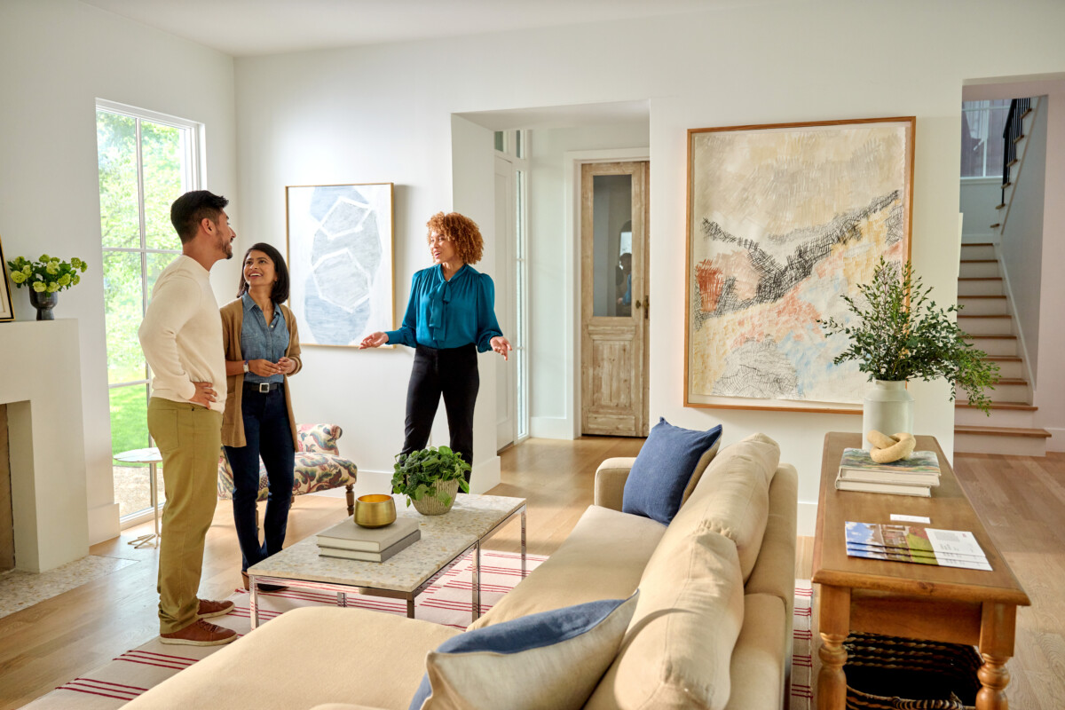 Homebuyers touring a property with their real estate agent, checking off items on their house hunting checklist