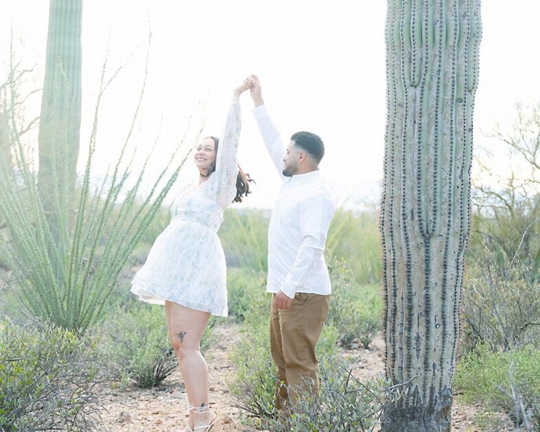 A photo of a happy couple dancing in the saguaro cactuses.