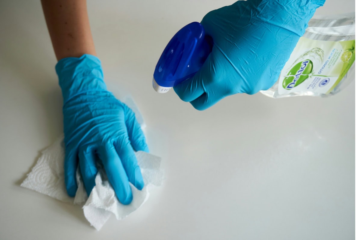 Two hands cleaning a surface