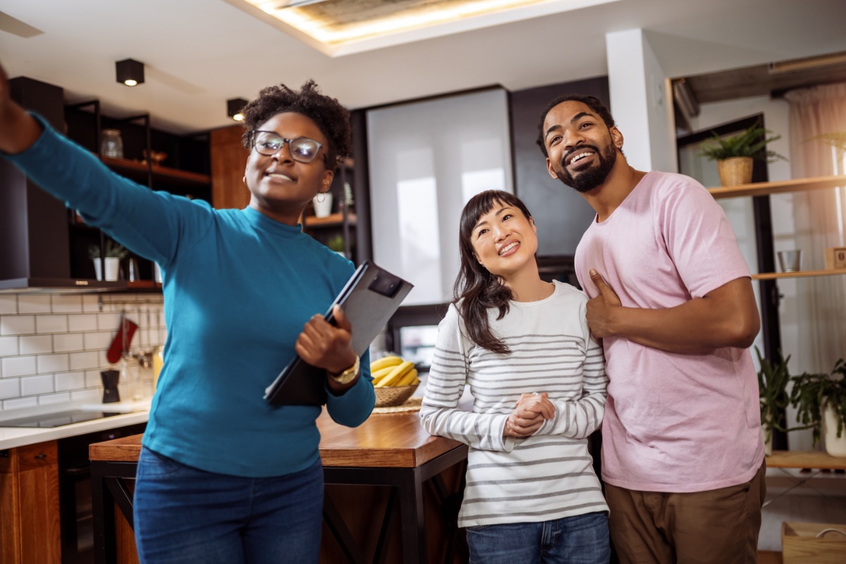 A real estate agent showing a home to a couple, illustrating the concept of buyer concessions in a home purchase.