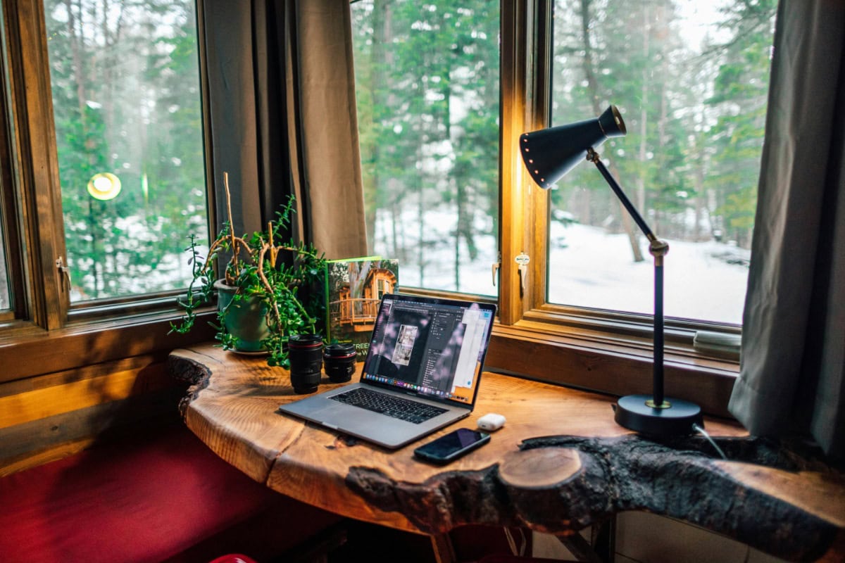 Laptop on wooden desk with warm lighting