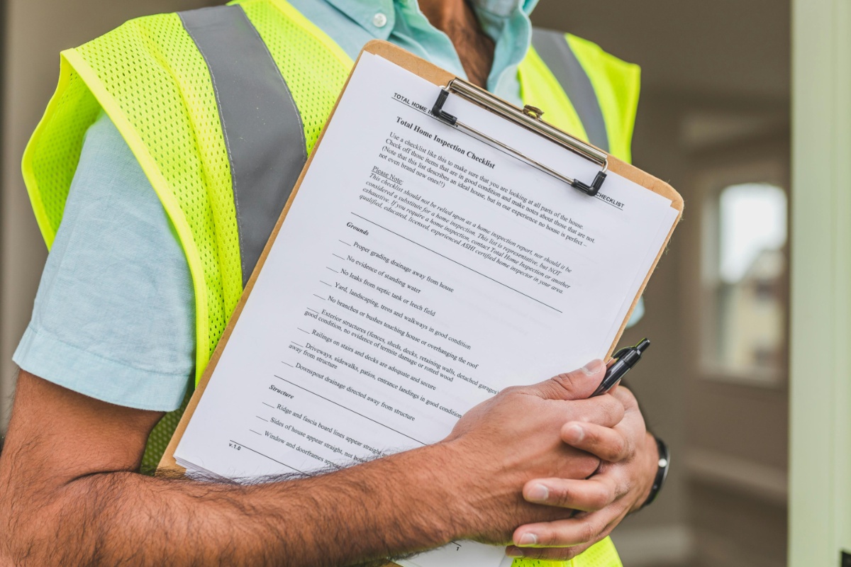 A home inspector holding a clipboard with a comprehensive checklist, focused on examining a property.
