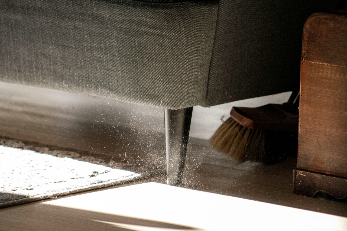 Broom sweeping under a couch