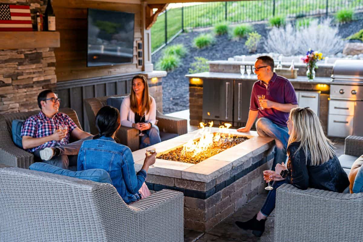 People sitting around a fire pit at an open house using creative ways to market a home.