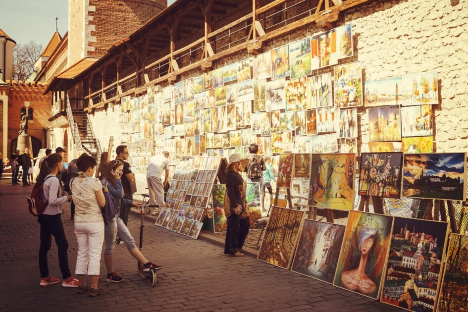 People looking at paintings and art of the street