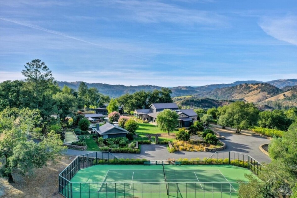 Country mansion equipped with its own tennis court, pool, and outdoor living space.