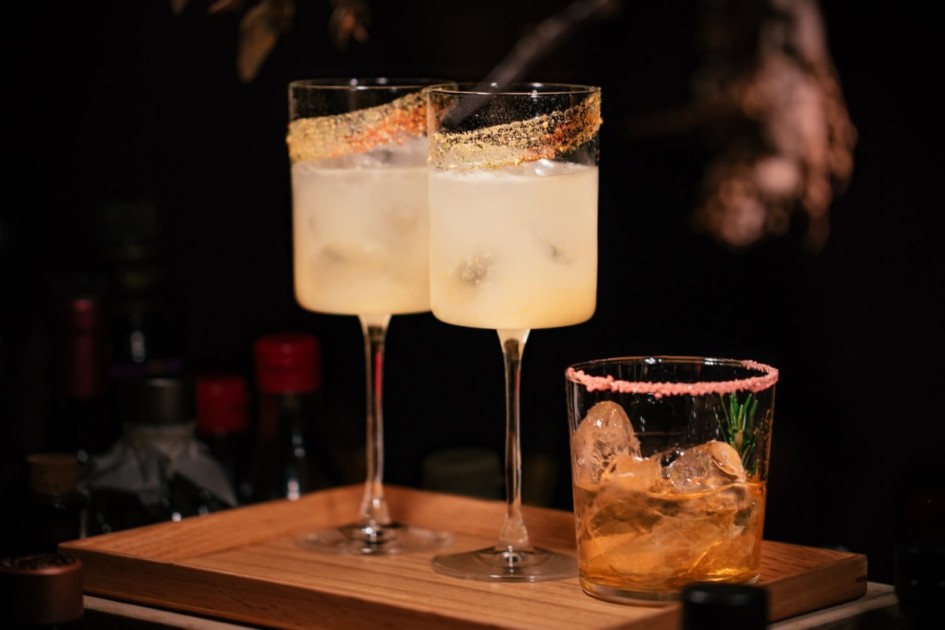 Two cocktails and a whiskey glass with a salt rim