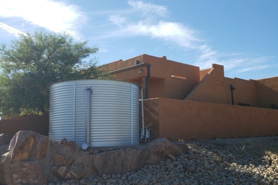 a pueblo home with a large metal rain barrel tank