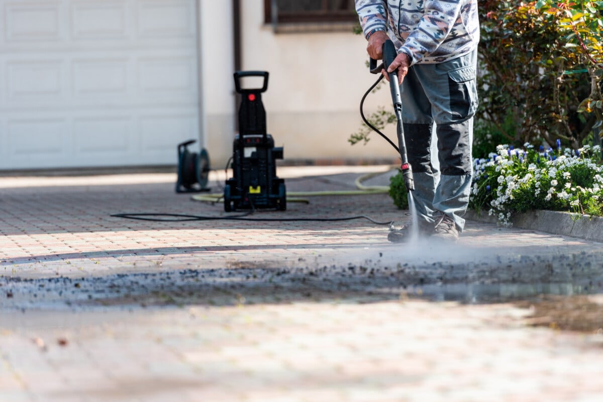 Homeowner pressure washing driveway