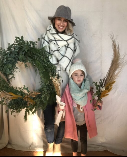 A mother and daughter holding wreath foraged wreath materials