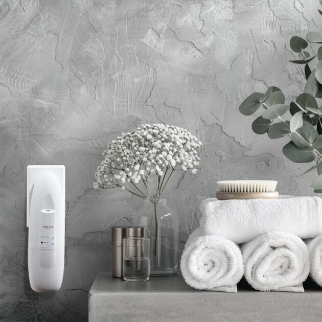 Towels and toiletries on counter with greenery