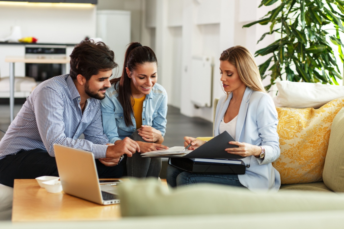 Couple looking over paperwork with their real estate agent