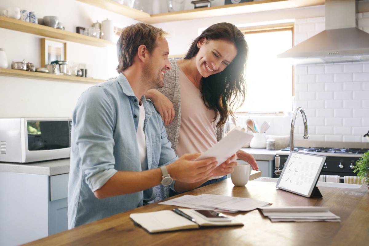 Joyful couple looking over their well organized real estate paperwork