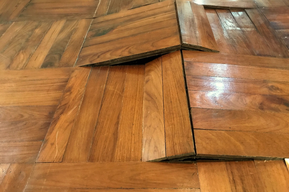 Wood floor warping after water damage was left untreated