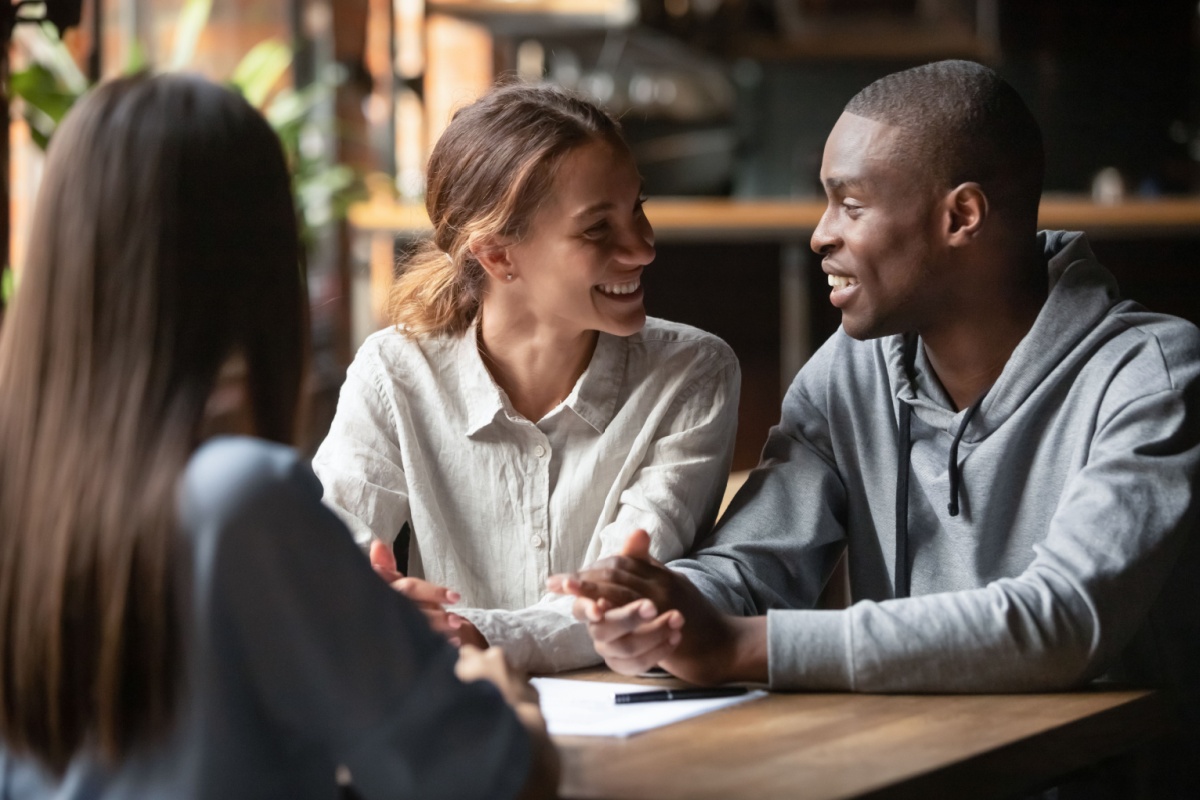 Couple talks with their Redfin agent at a coffee shop before closing on their house