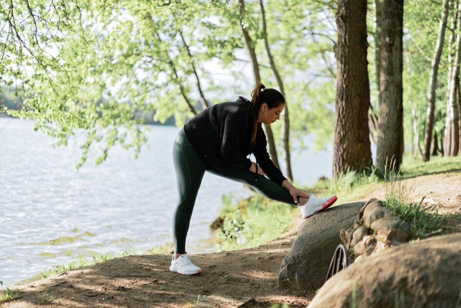 Woman stretching by water