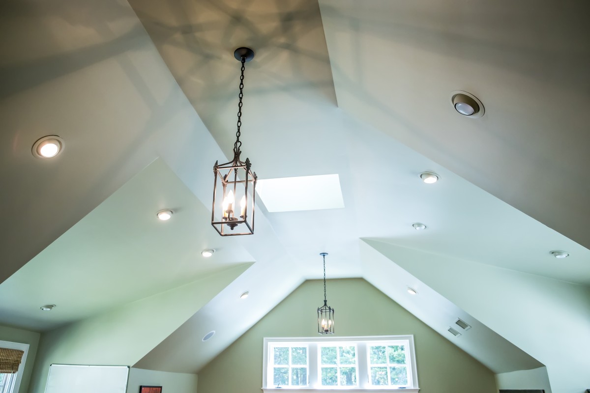 Vaulted ceiling with a modern Gothic mid evil iron metal hanging lights and a green walls