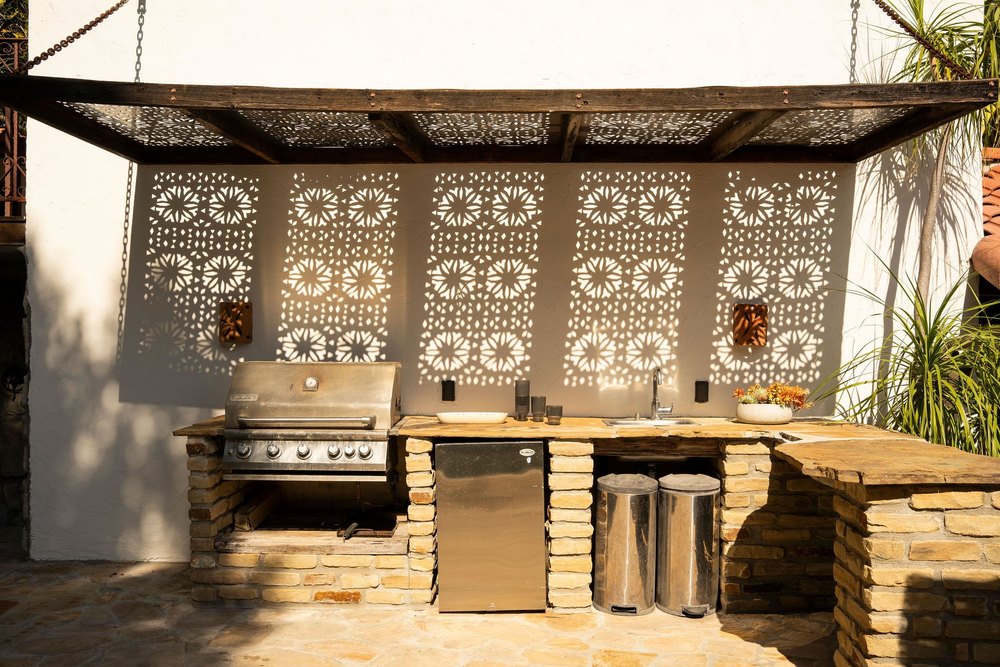 An outdoor kitchen with a bbq and fridge at actress Malin Akerman home in Los Feliz California