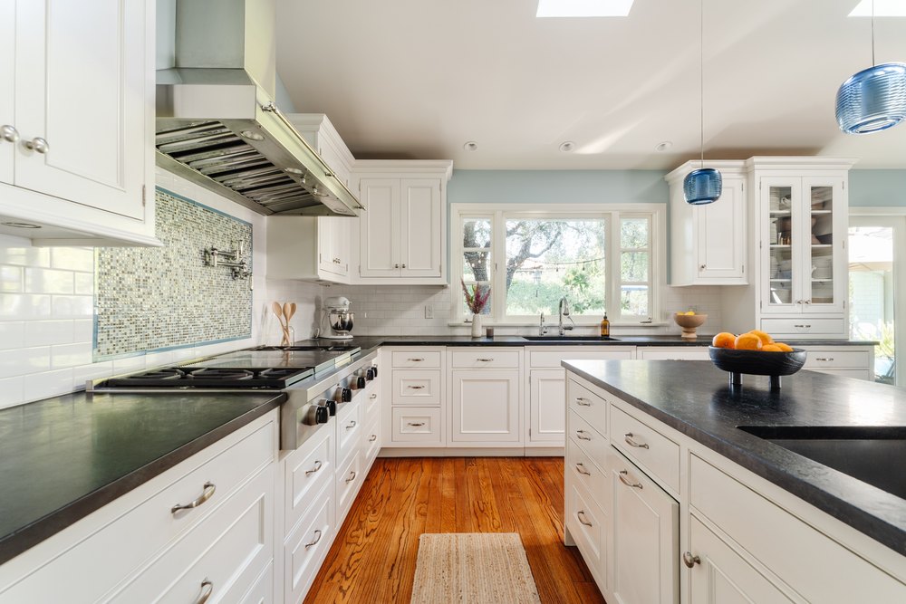 A detailed view of the kitchen's cooking area, showcasing a large stainless steel range under a professional vent hood.