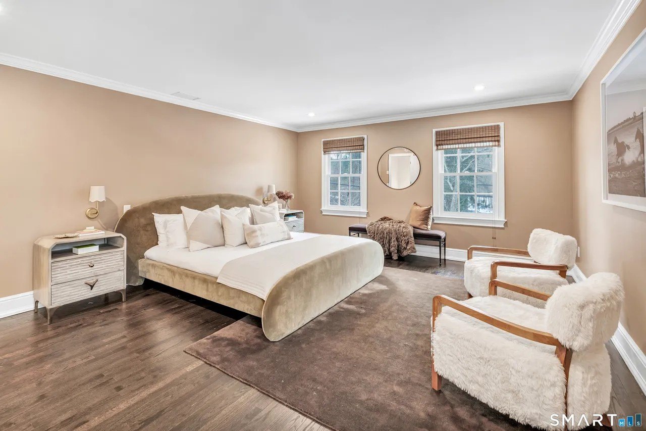 A bedroom with a velvet bed in Paige Lorenze Connecticut home