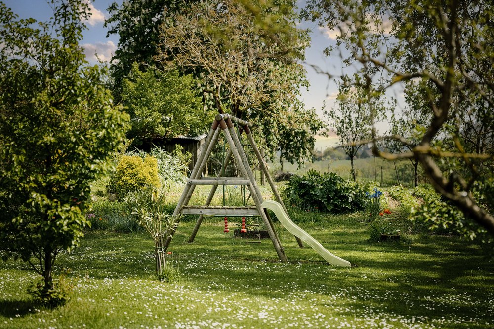 A wooden swing in a traditional garden in the countryside.
