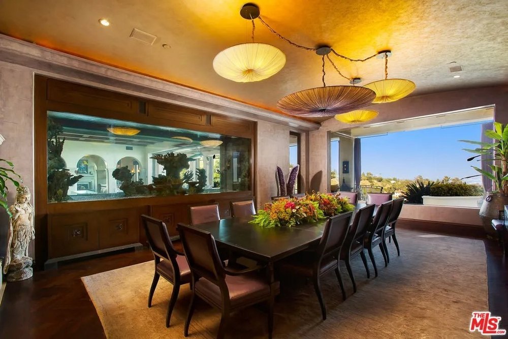 Dining table with a fish tank in a home on the land where sharon tate was murdered