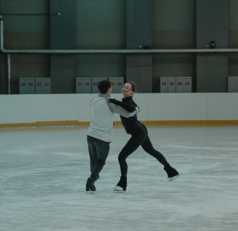 Man and woman dancing in the ice rink wearing ice skating shoes