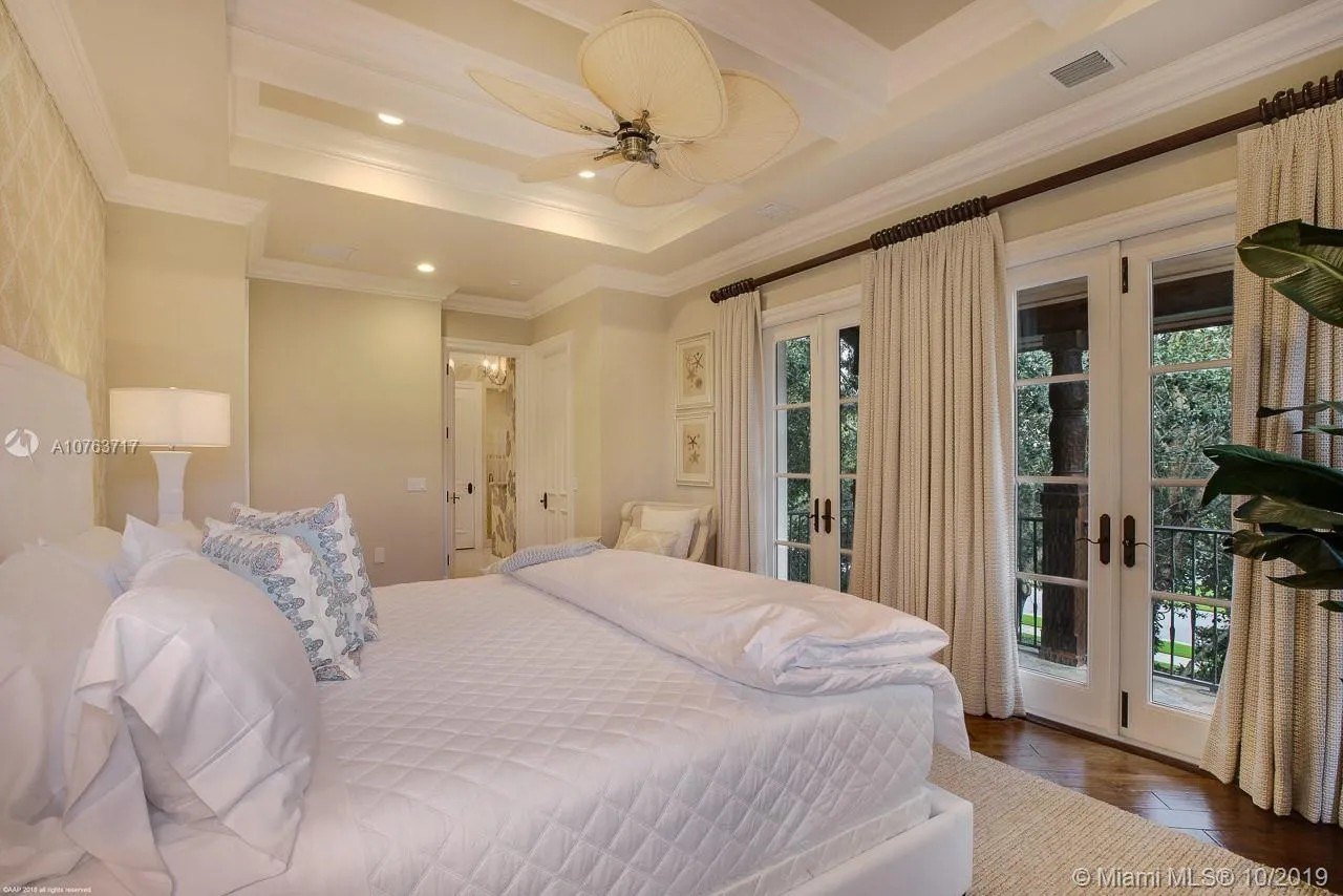 A bedroom with french doors leading to a balcony at Greg Normans Palm Beach Mansion