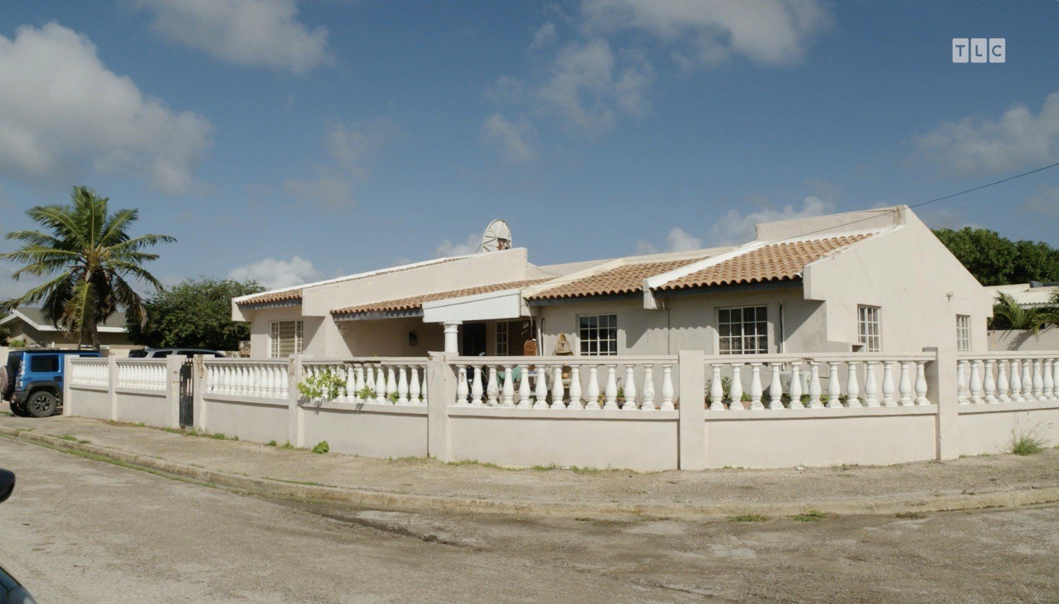 Fernandes' home is a a beige corner house with a clay tile roof.