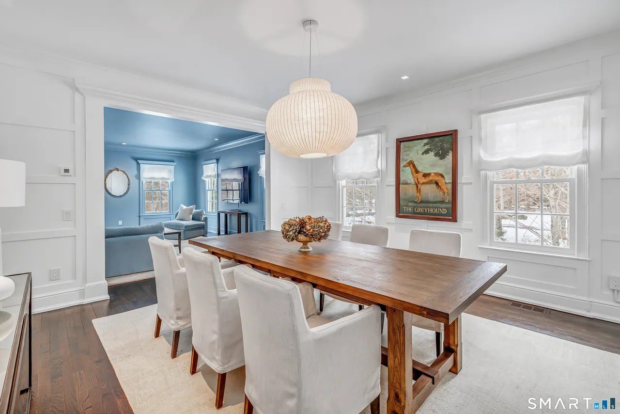 Dining room with a wooden table and white walls in Paige Lorenze Connecticut home