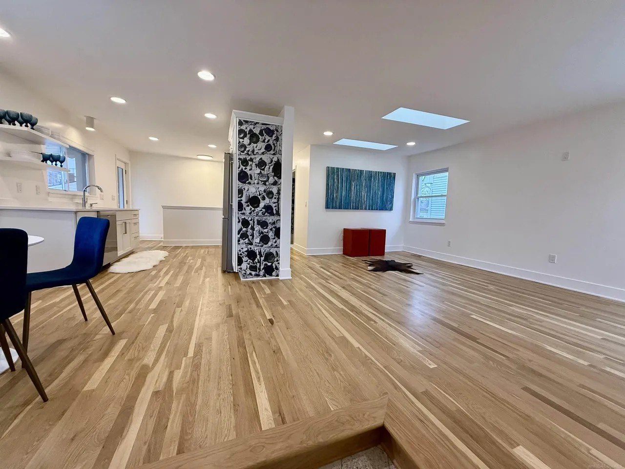 The home now features a wide open great room. Note the homage to the bottles in the wallpaper on the room divider.