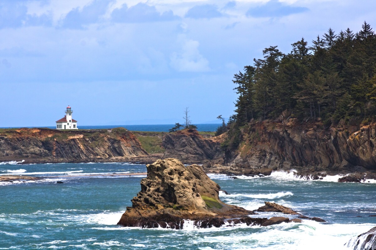 coos bay rock and wooded area with ocean waves