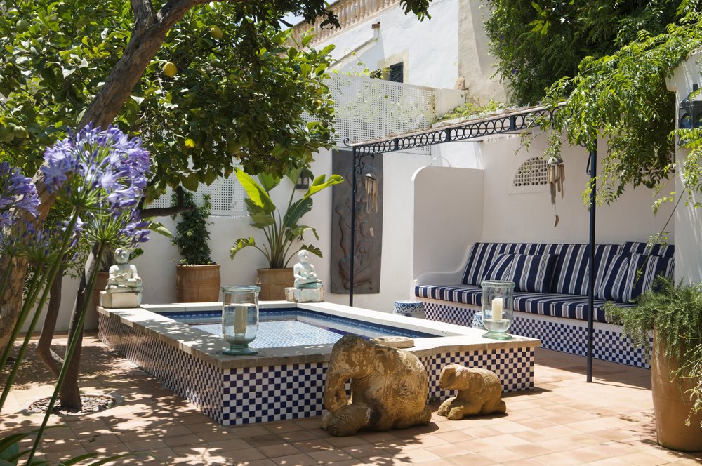 Plunge pool with striped seating area in shade of fruit tree
