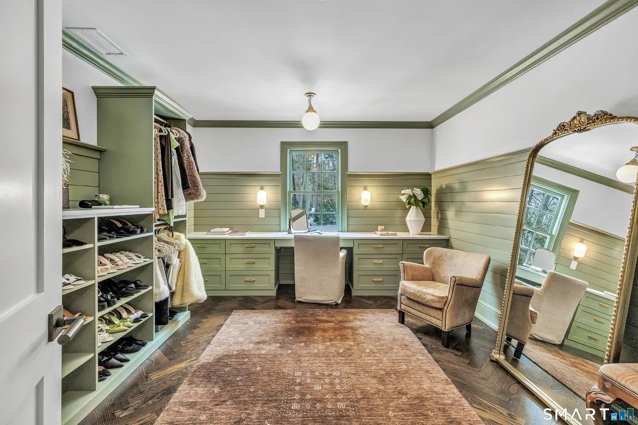 A closet with a large gold mirror in Paige Lorenze Connecticut home