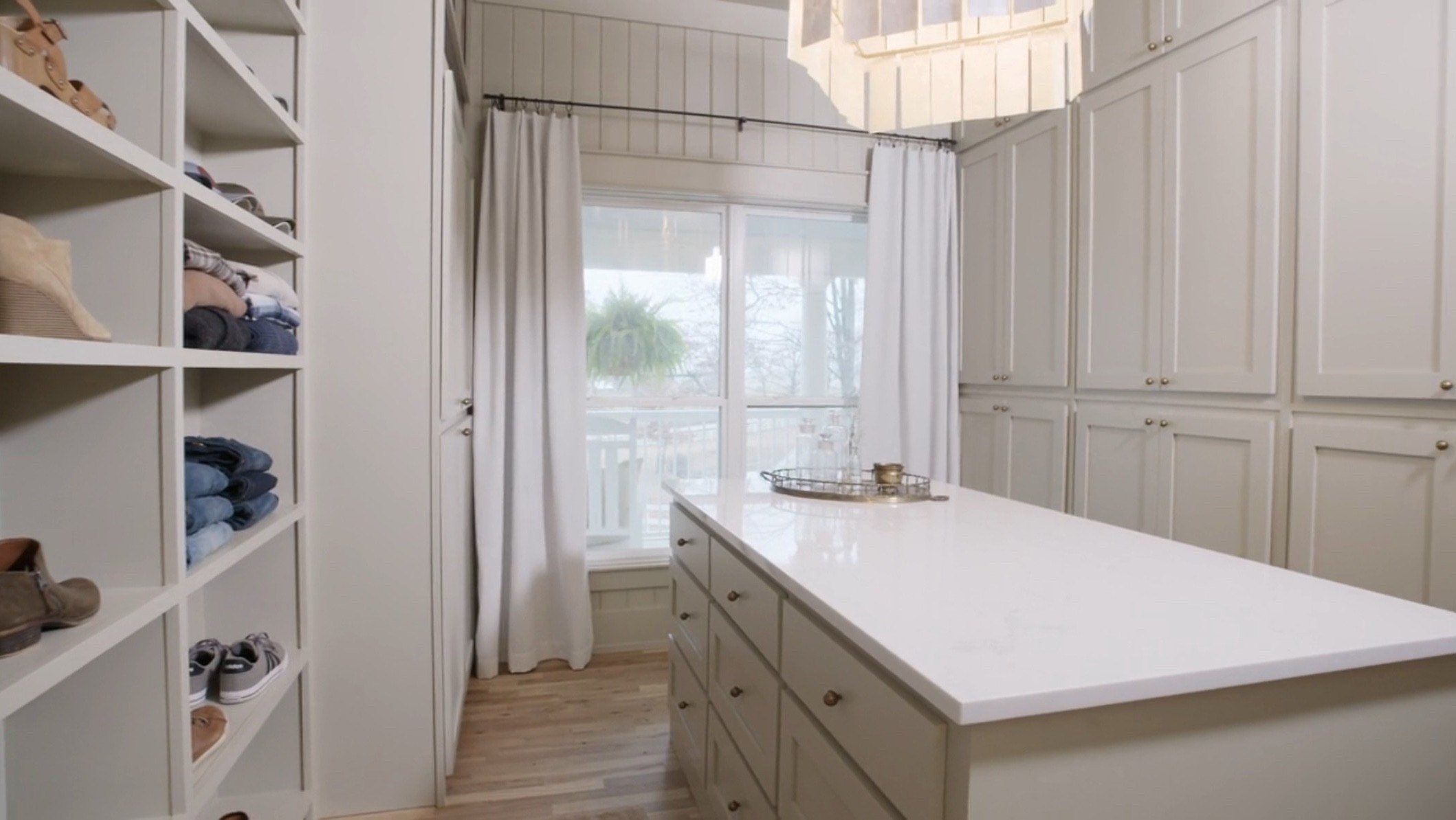 The new primary closet space includes open shelving, cabinetry, and a closet island. 