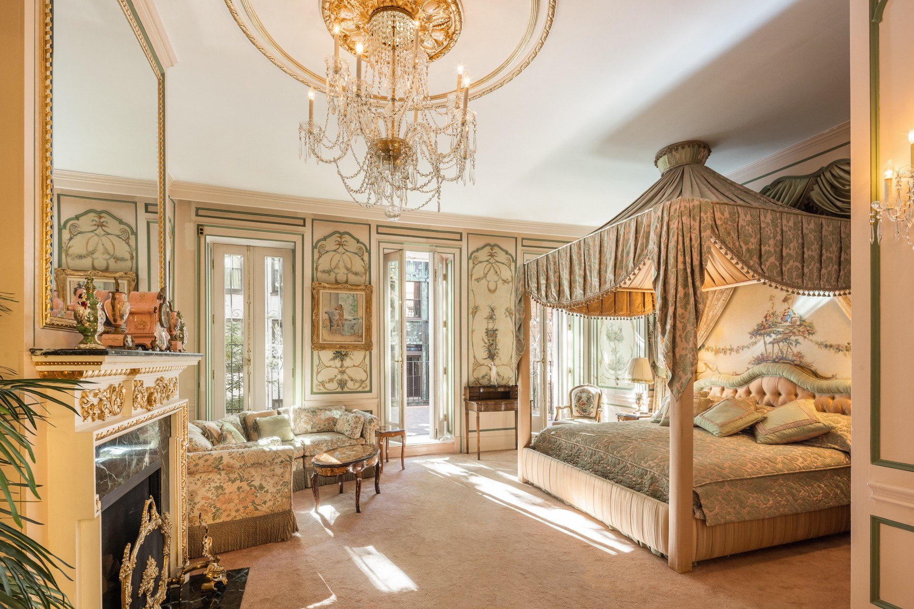 A bedroom with an opulent chandelier and fireplace in a townhome in Manhattan owned by Ivana Trump