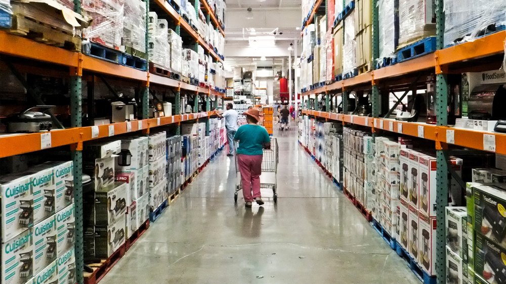 a female shopper walks the aisles of warehouse retailer COSTCO
