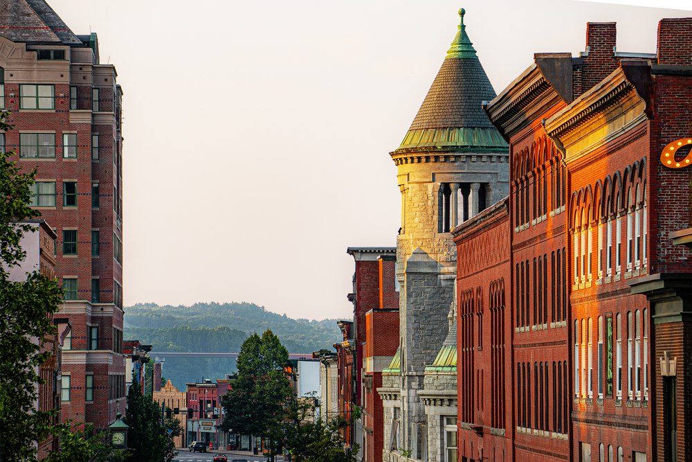 Looking down Main Street in Bangor, Maine with hills and forests in the distance