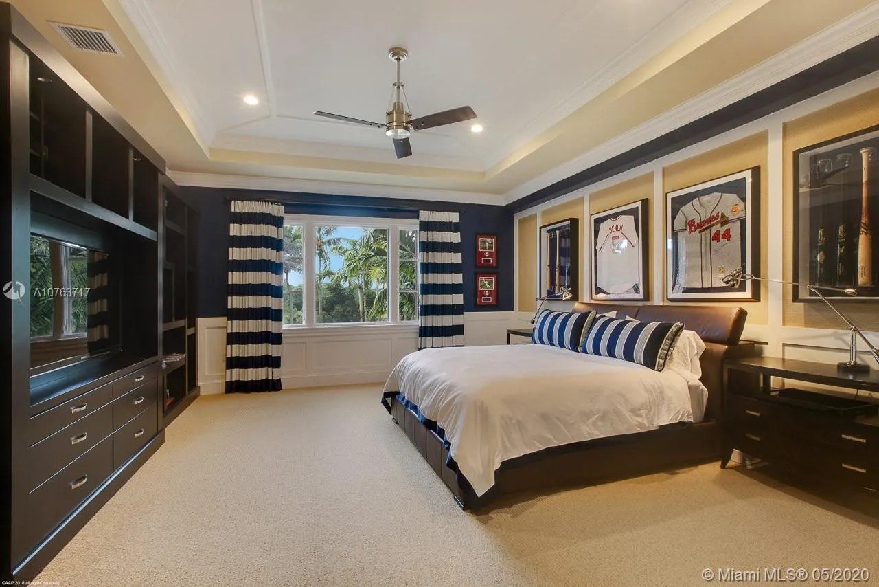A bedroom with striped curtains in Greg Normans Palm Beach Mansion