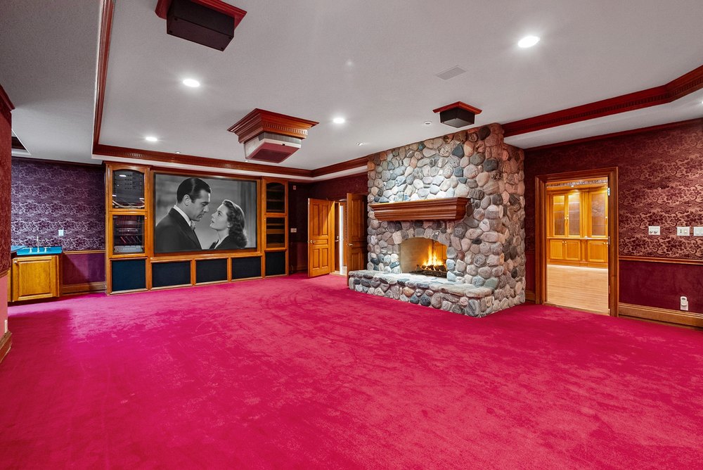 Home Theater Room with Projector Screen, Stone Fireplace, and Red Carpet