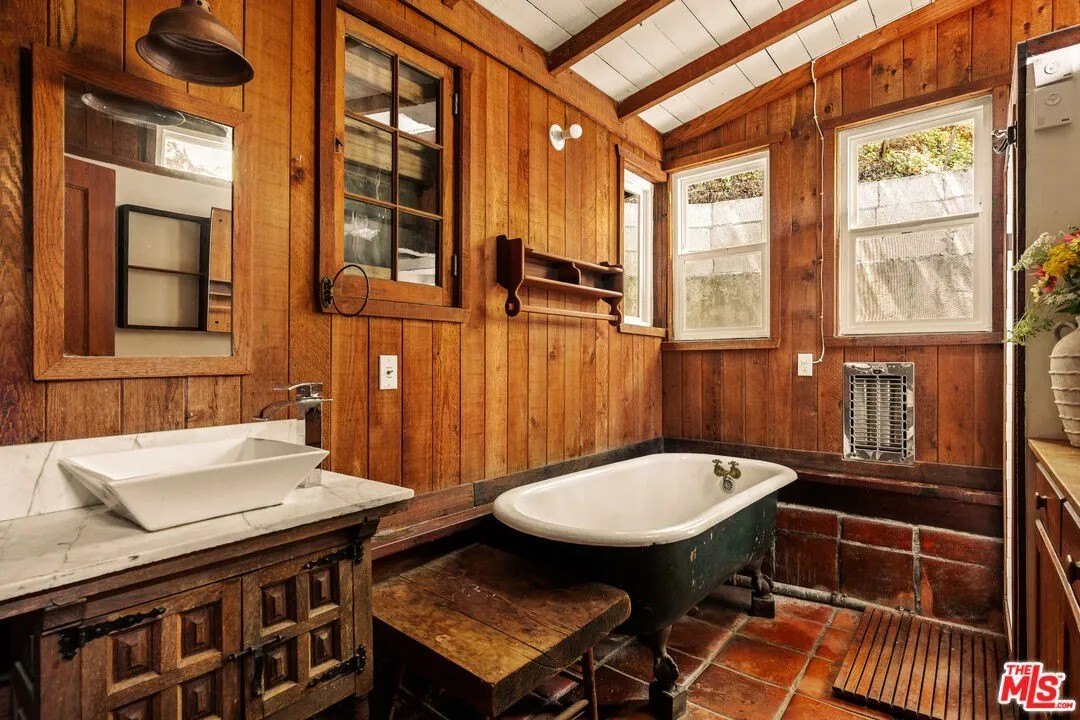 The wood paneled bathroom The bathroom's plumbing has been redone, but an antique, claw-foot tub is a reminder of the home's heritage.