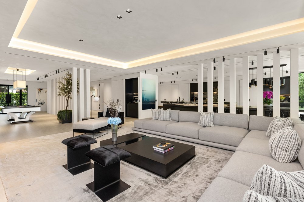 Open-Concept Living Room with Sectional Sofa, Recessed Lighting, and Slat Partition