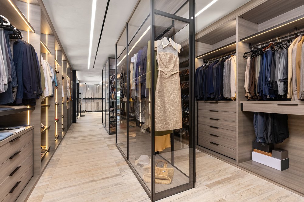 Walk-In Closet with Built-In Lighting, Wood Cabinetry, and Glass Display Case
